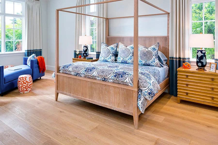 Modern bedroom featuring a wood four-poster bed with blue patterned bedding and cozy decor.
