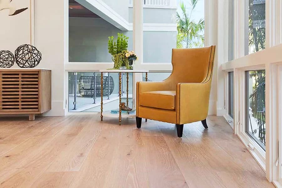 Modern living room with yellow armchair, wooden flooring, and decorative plants.